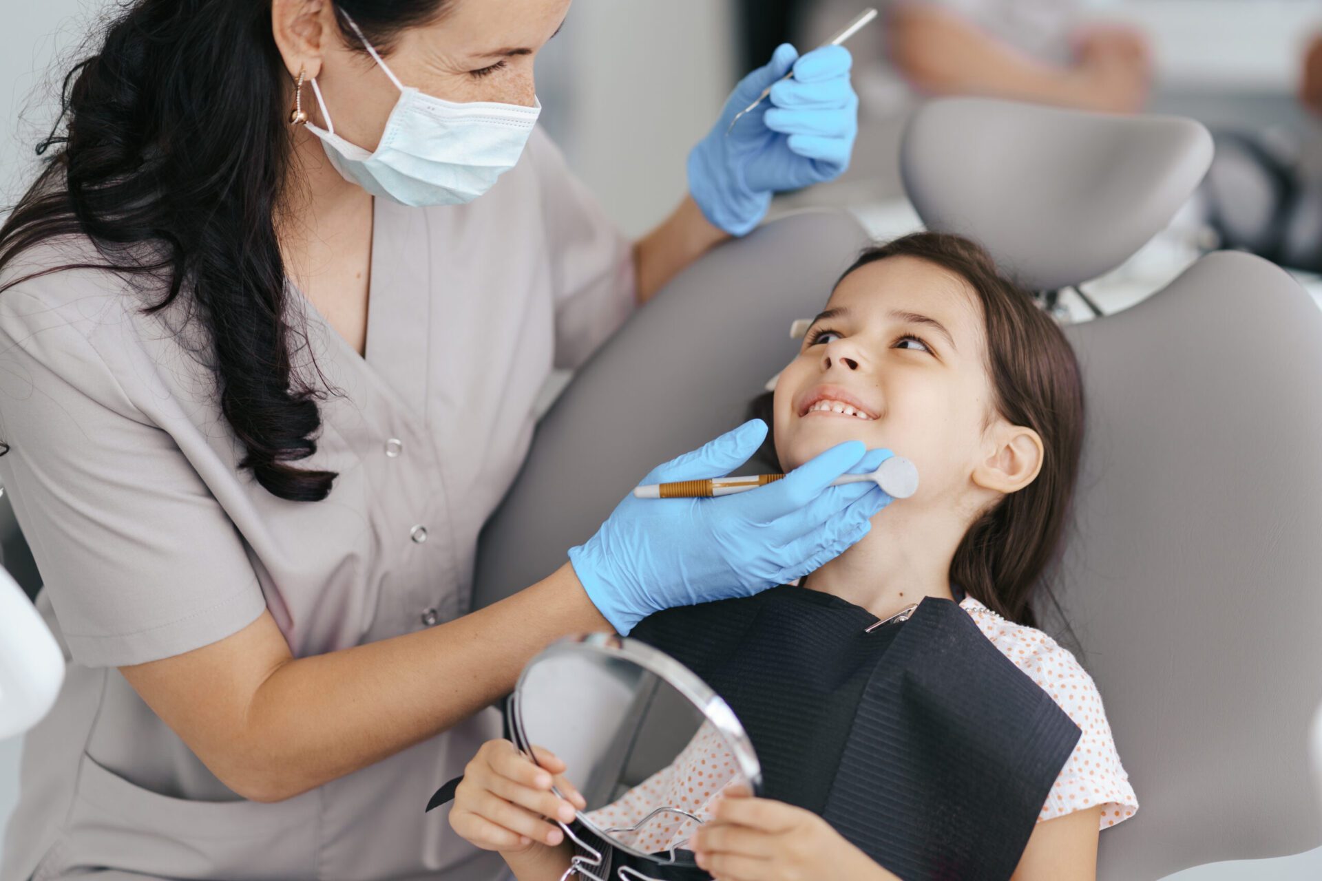 Female dentist examining kid's teeth